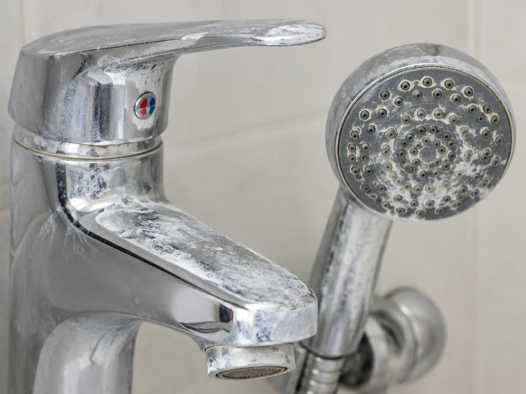 Hard water limescale on a bathroom tap and showerhead
